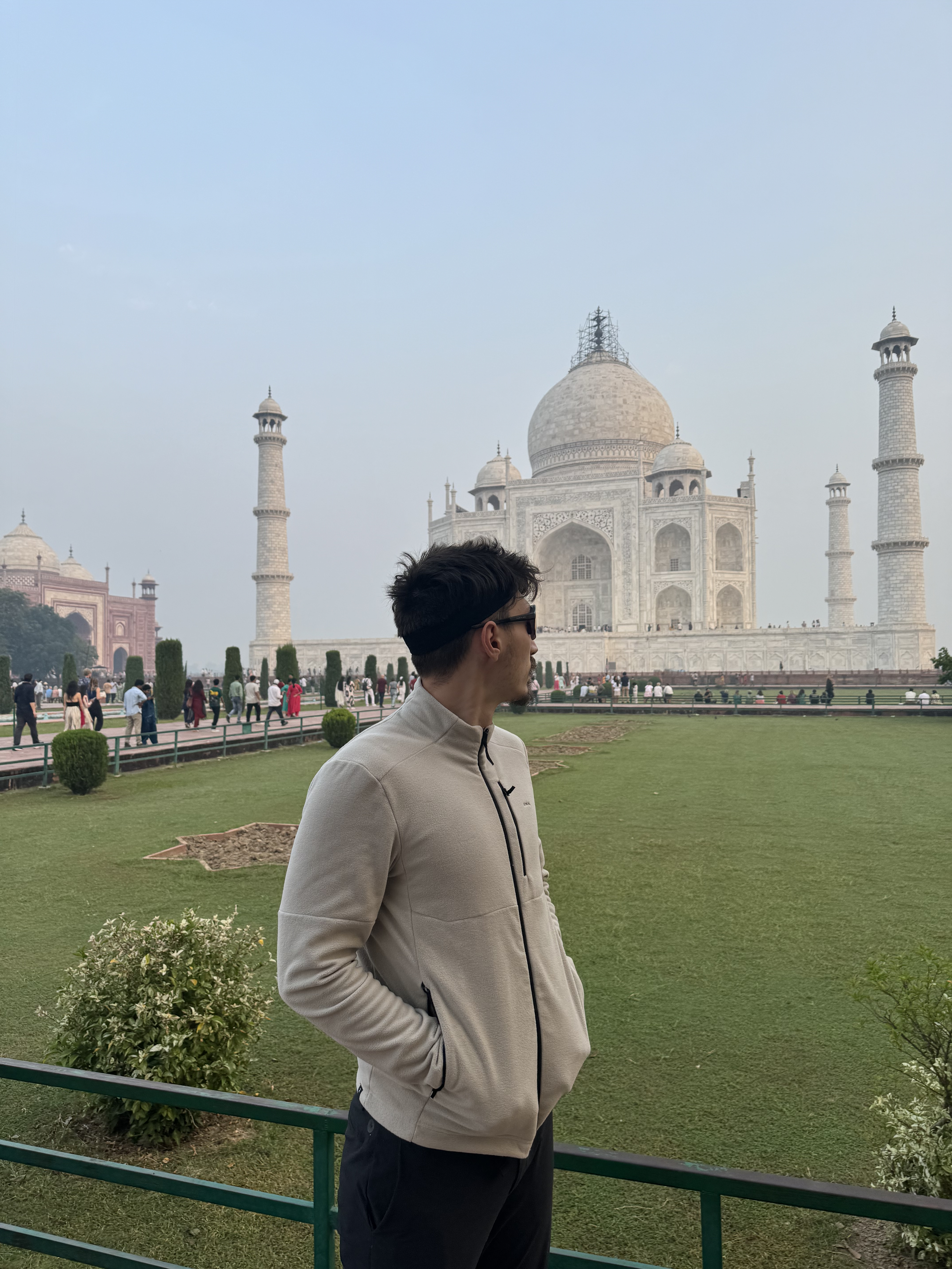 Traveler standing in front of the Taj Mahal in Agra, India, on a hazy day